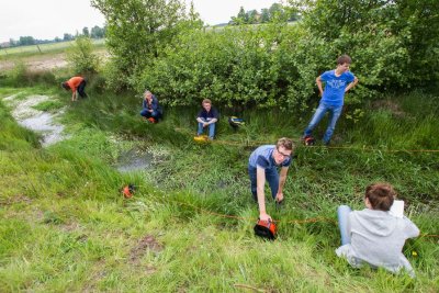 Ares students working on a project in a ditch